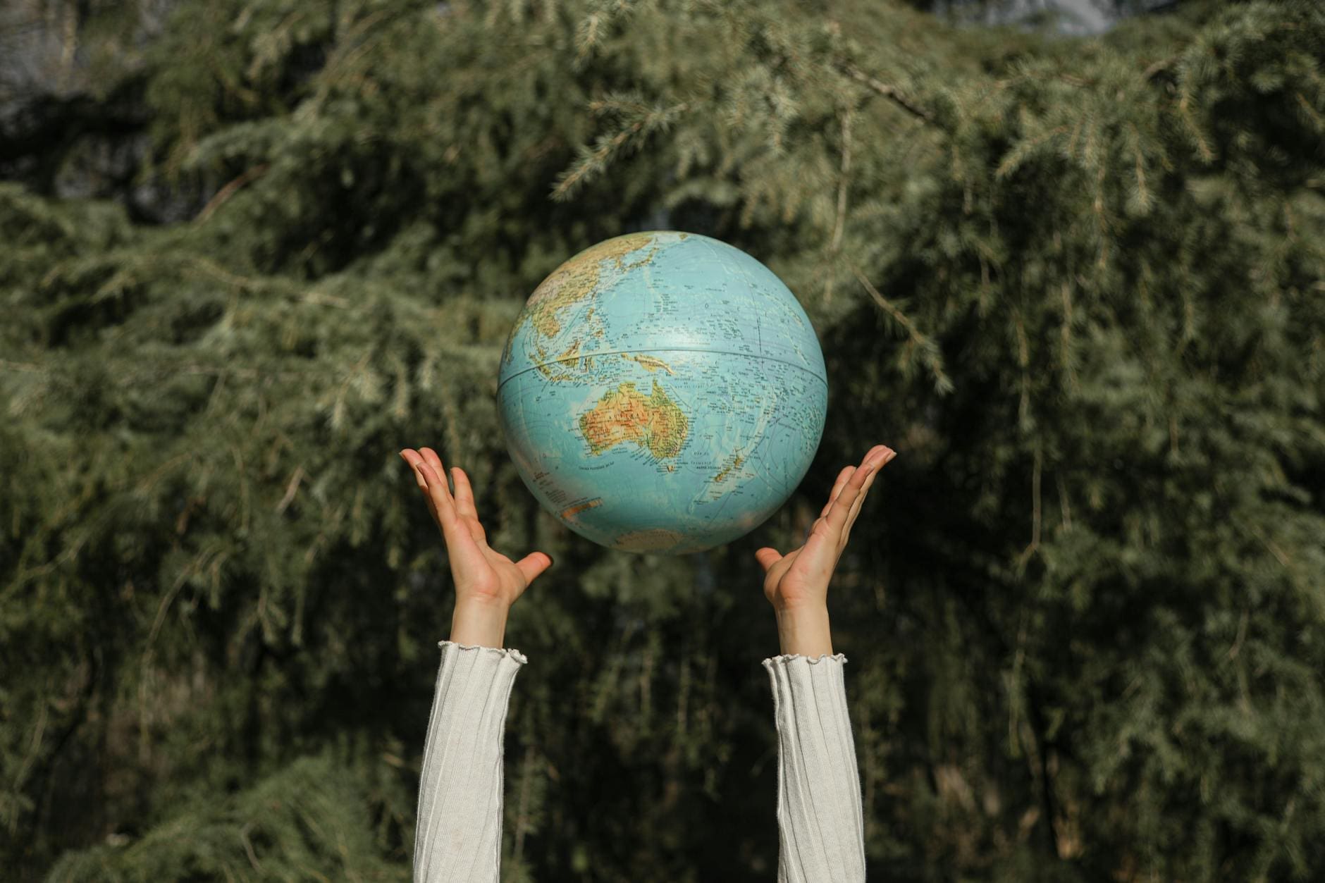 person tossing a globe